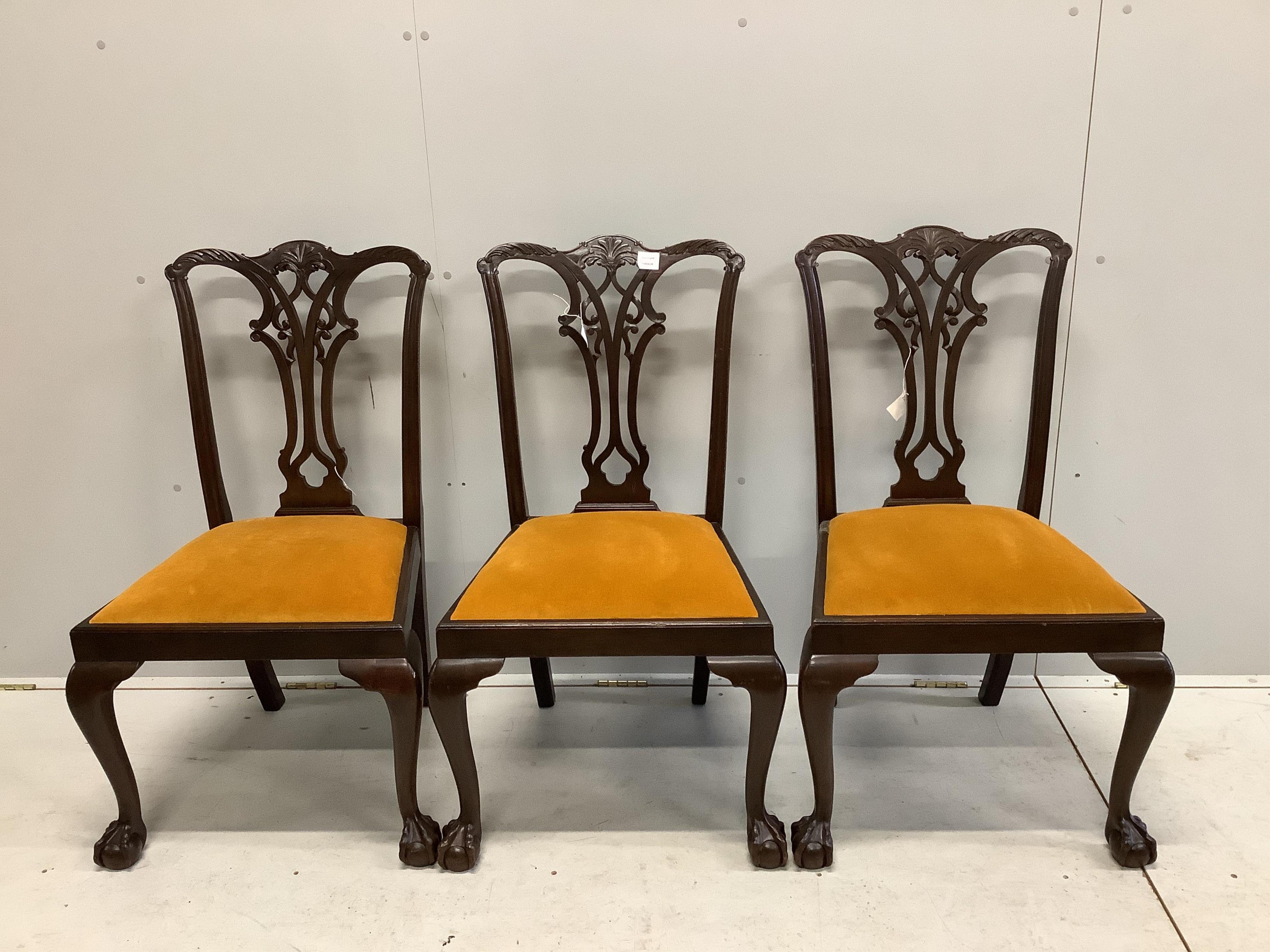 Four Chippendale style mahogany dining chairs, with pierced, interlaced splats above old gold velour drop in seats, one with arms. Condition - fair